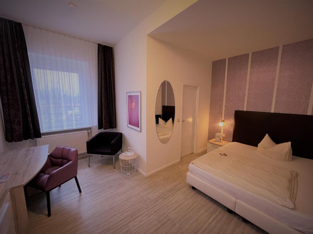 盖尔森基兴阿瑞纳酒店的一间卧室配有一张床、一张桌子和一把椅子