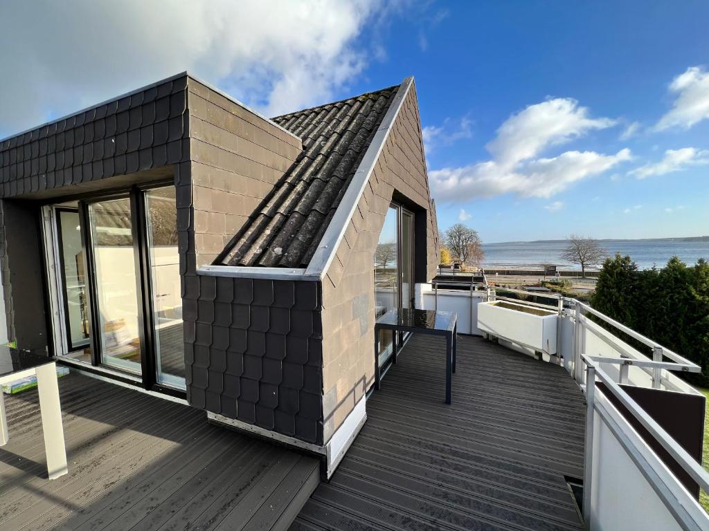 哈里斯莱BEACH HOUSE II - Penthousewohnung in Bestlage mit sonniger Dachterrasse und top Meerblick的甲板上黑色屋顶的小房子