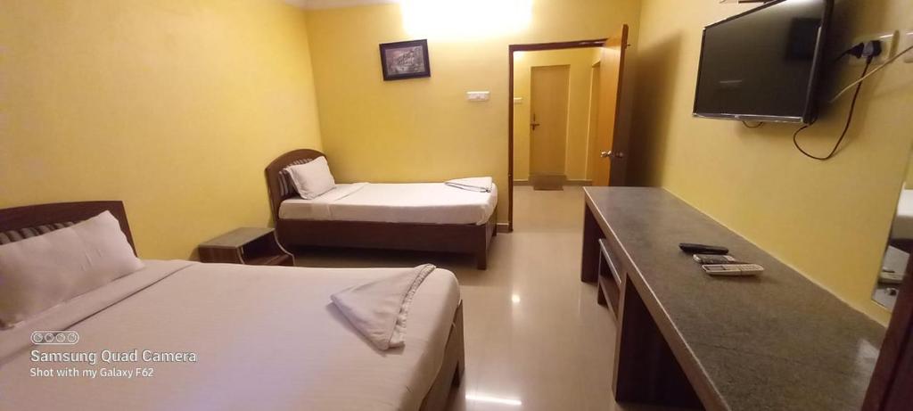 维沙卡帕特南Royal Stay的一间酒店客房,设有两张床和电视