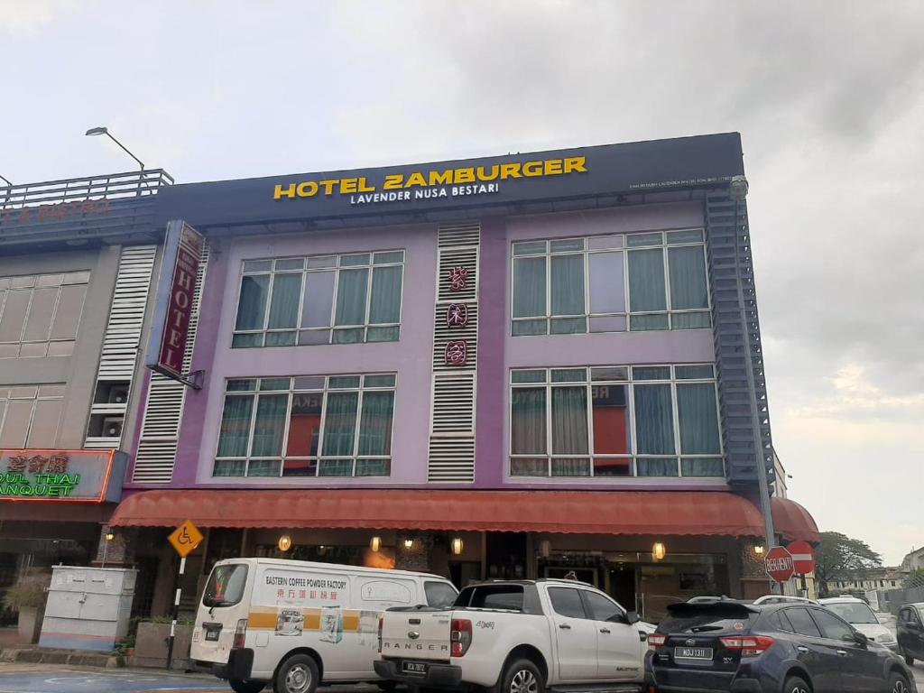 新山Lavender Inn Nusa Bestari的酒店庭院前面设有停车场