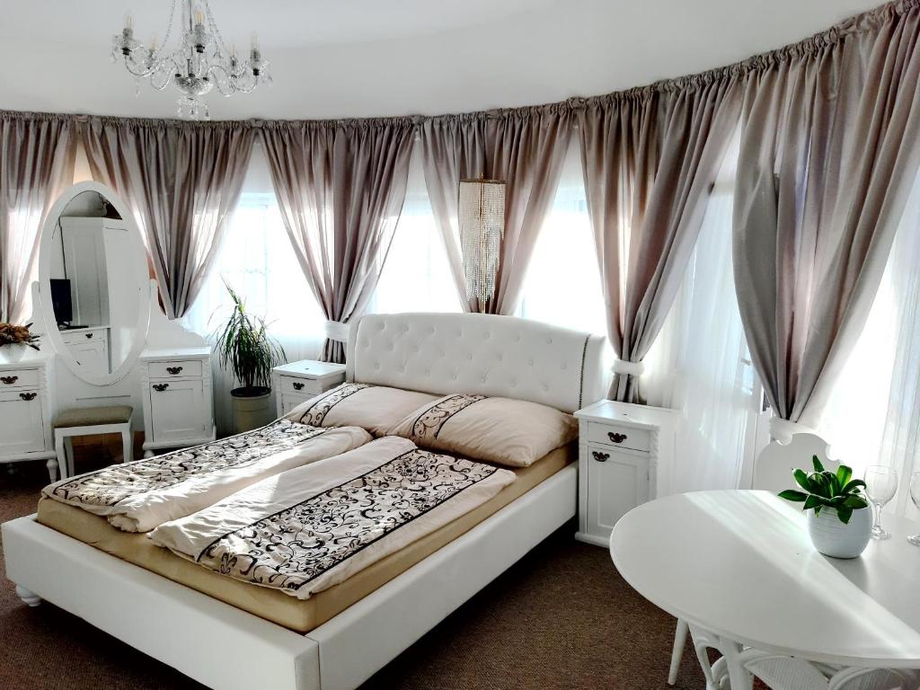 亚希莫夫Penzion a Restaurace Belveder的卧室配有一张白色的大床和一张桌子