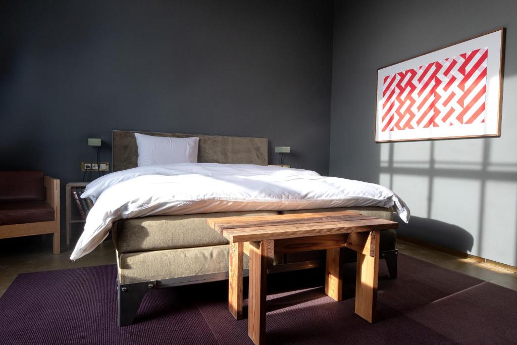 埃因霍温Hotel Piet Hein Eek的一间卧室配有一张床和一张木桌