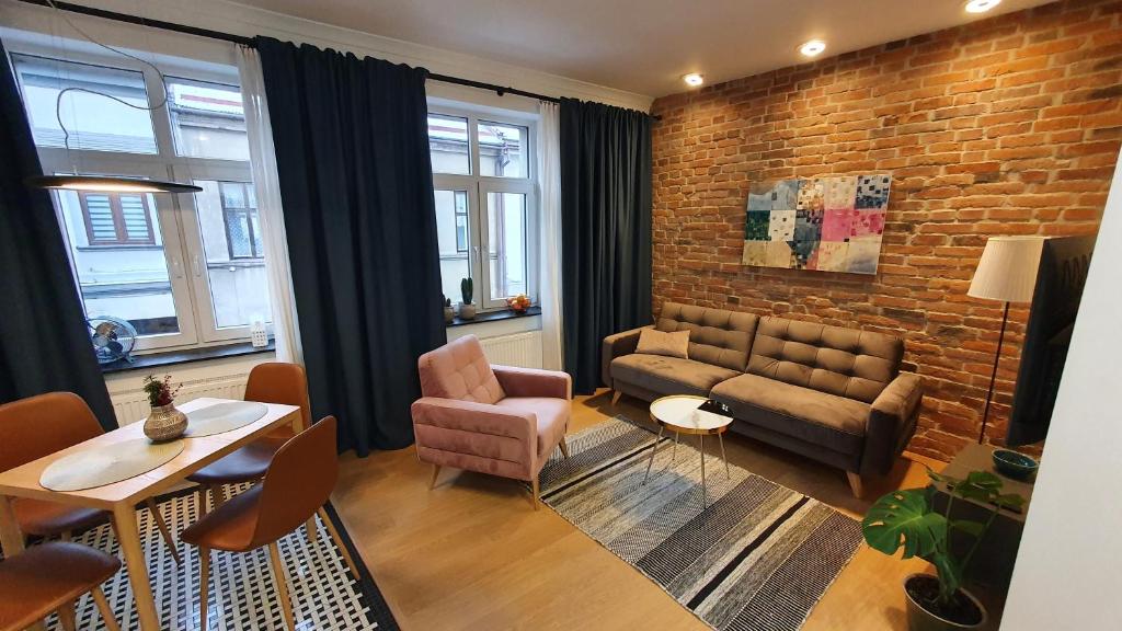耶维克Apartamenty SIENKIEWICZA 8的带沙发和砖墙的客厅