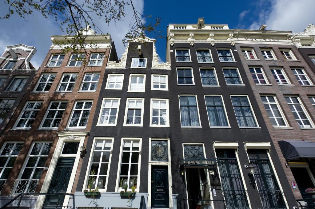 阿姆斯特丹运河住宅的城市街道上一座高大的建筑,有白色的窗户