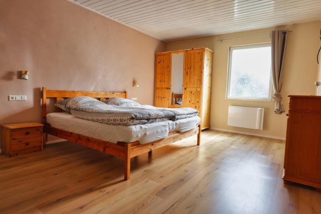WernesgrünFerienwohnung Steinberg mit Sauna的一间卧室设有一张木床和一个窗户。