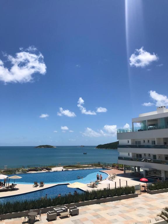 弗洛里亚诺波利斯ACQUA MARINE FLORIPA Apto com vista para o mar!的一座以海洋为背景的度假游泳池