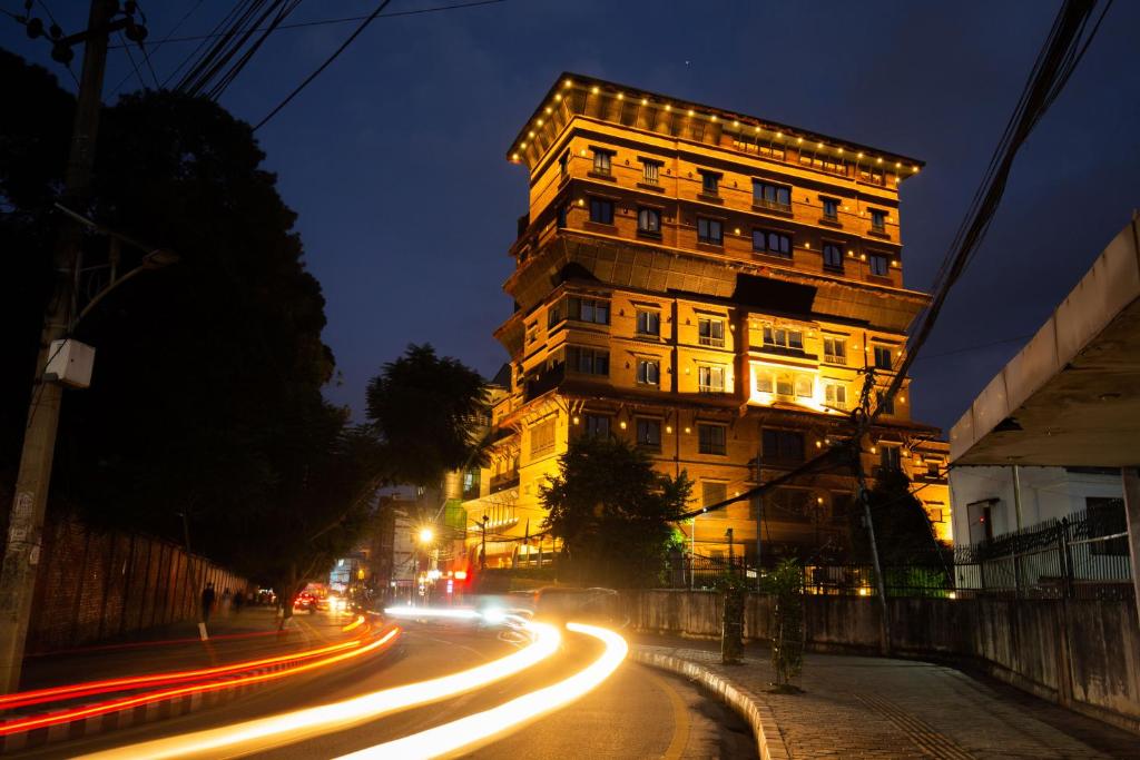 加德满都Basera Boutique Hotel的夜幕降临的城市街道上一座高楼