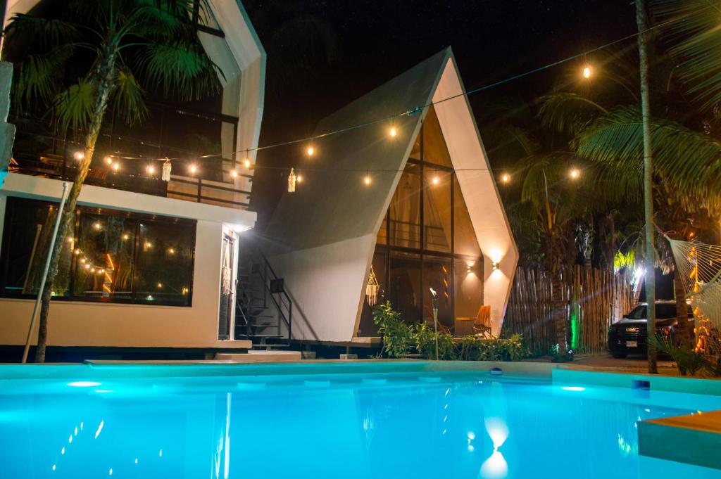 埃尔库约Xtambaa Cabins & Spa Only Adults的夜间在房子前面的游泳池