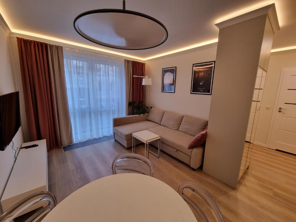 什切青Apartamenty 21 Śląska的客厅配有沙发和桌椅