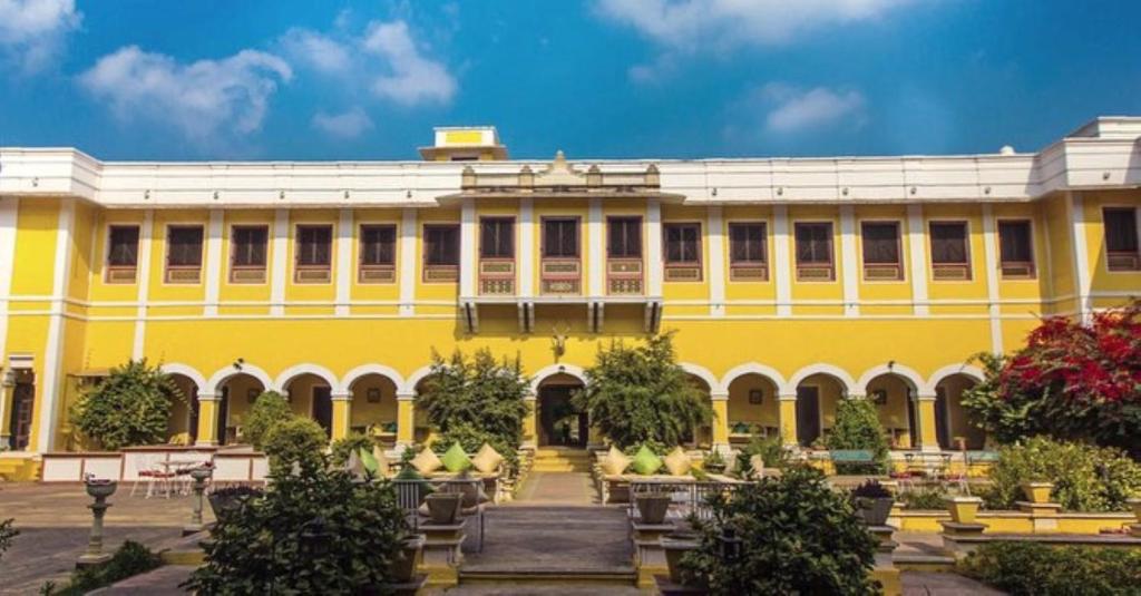 KarauliBhanwar Vilas Palace的前面有花园的黄色建筑