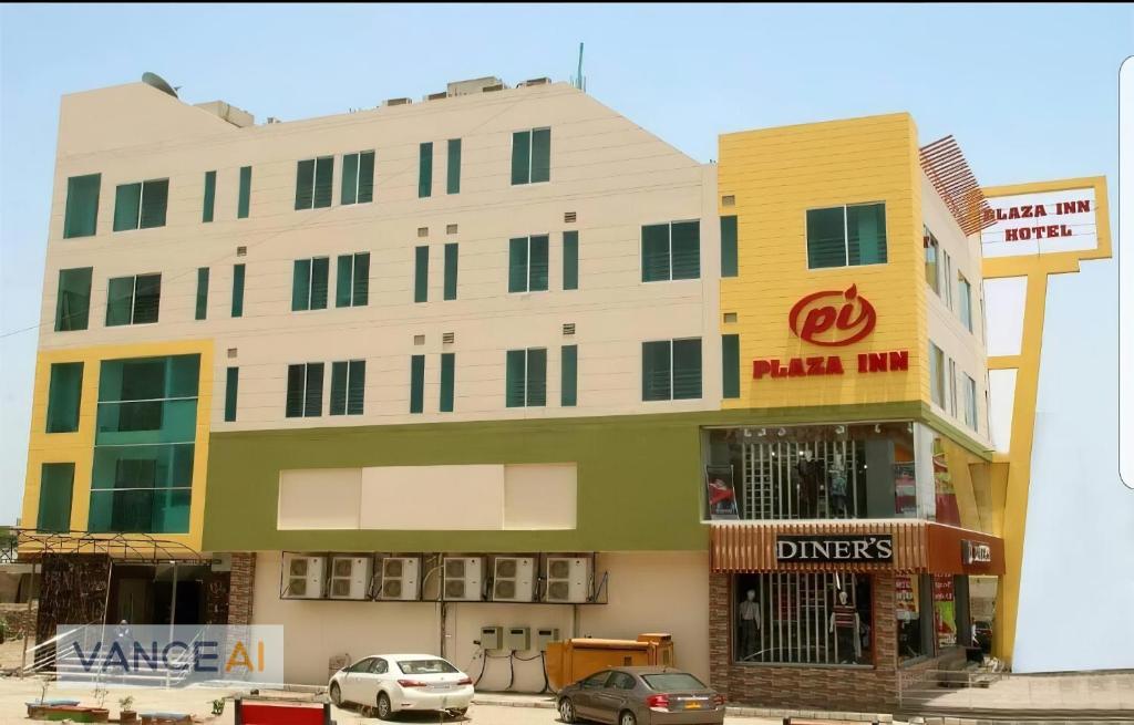 拉希迈尔汗Plaza Inn Hotel的前面有汽车停放的建筑