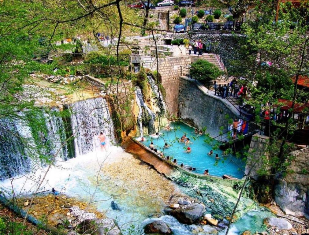 奥玛Guesthouse Tsoka的享有瀑布和游泳池内的人的景色