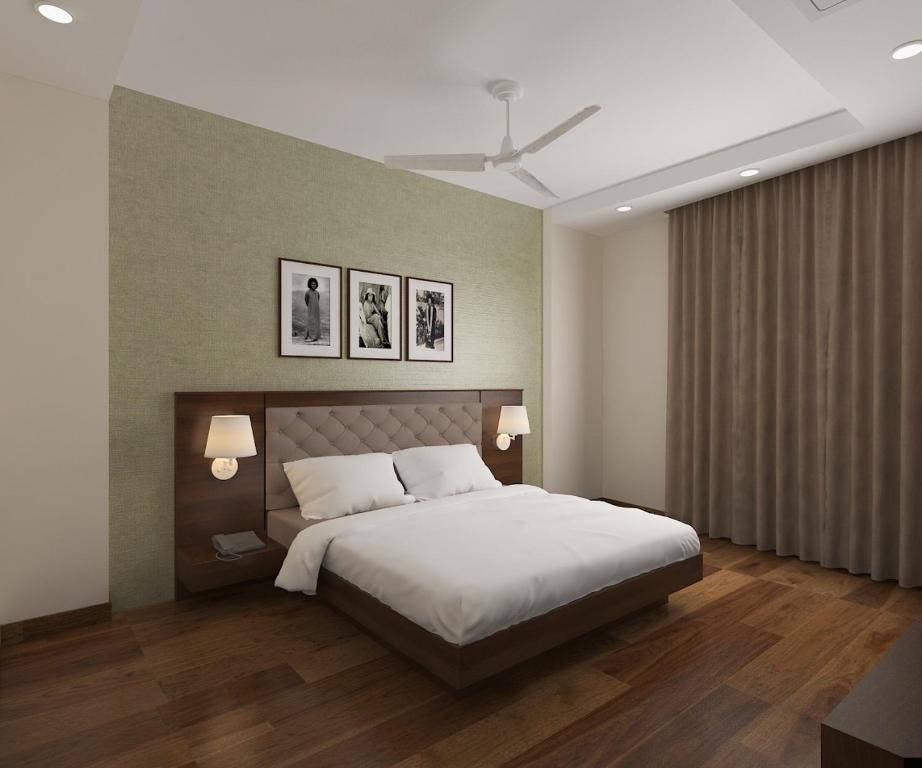 普塔帕蒂Sai Maa Hotel & Residency的卧室配有一张床,墙上挂有两张照片