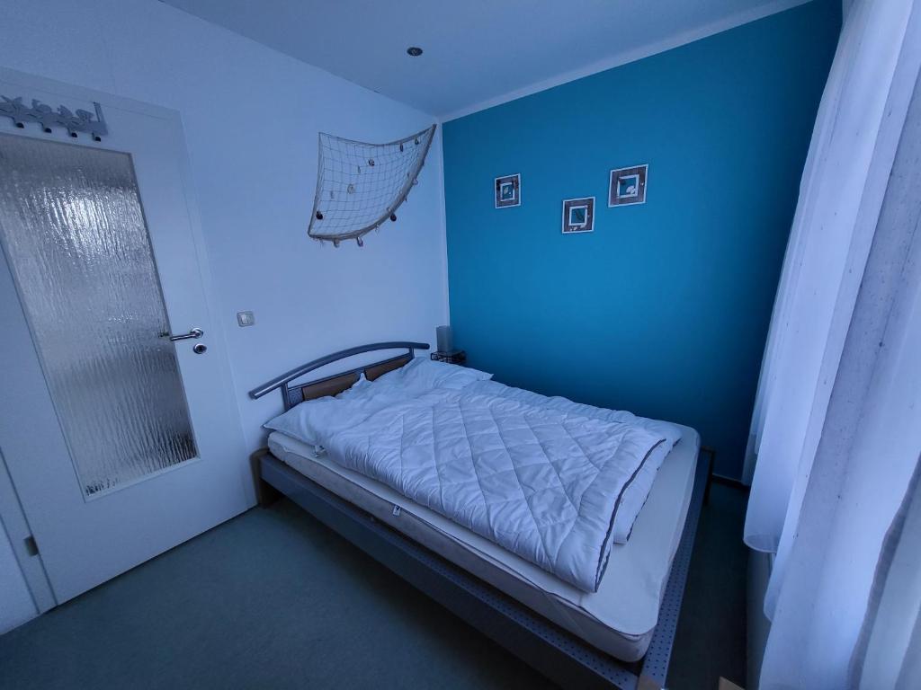 Usedom TownFerienwohnung Erika的蓝色的房间,设有床和蓝色的墙壁