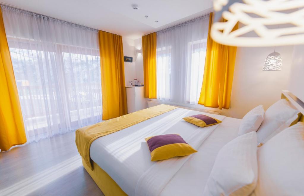 萨拉热窝里布利斯精品酒店的一间卧室配有一张带黄色窗帘的大床