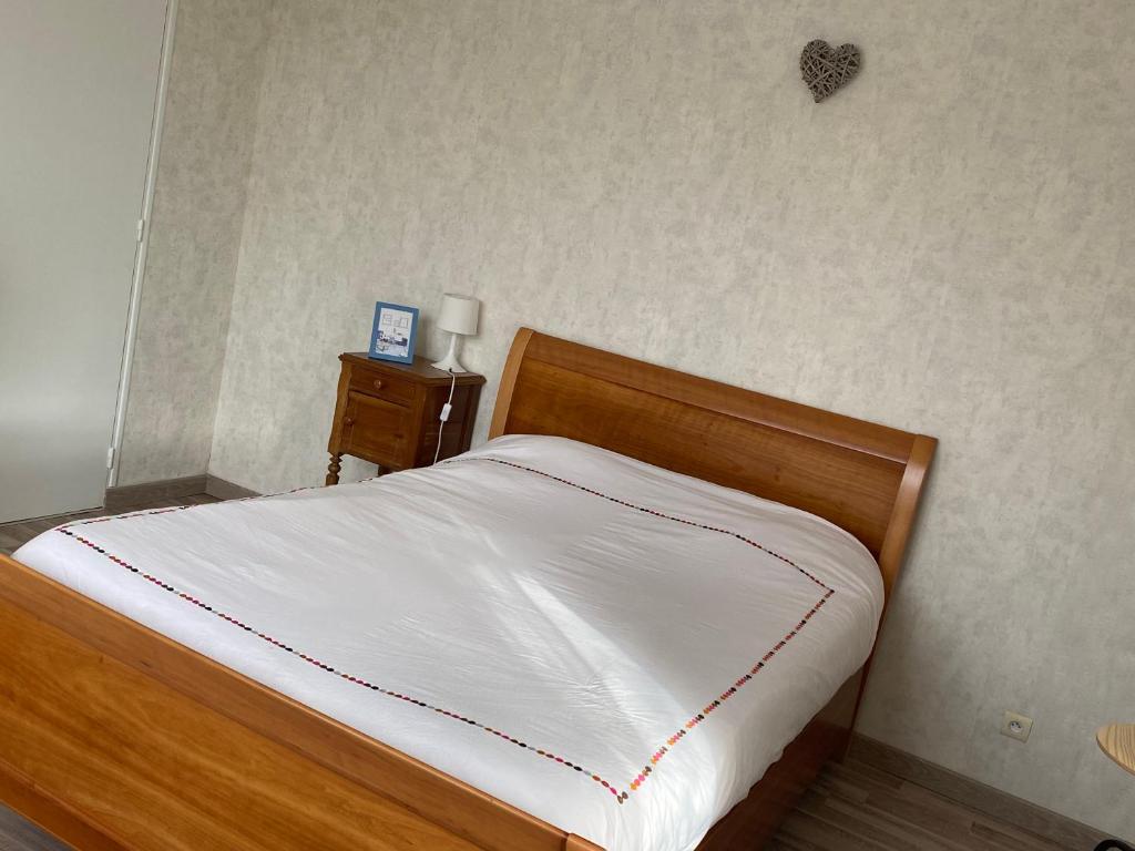 Saint-PorchaireChambre au bruand的一间卧室配有白色床单和床头柜。