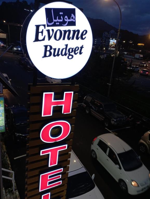 丹那拉打Evonne Budget Hotel的一张在停车场停车的便条汉堡标志