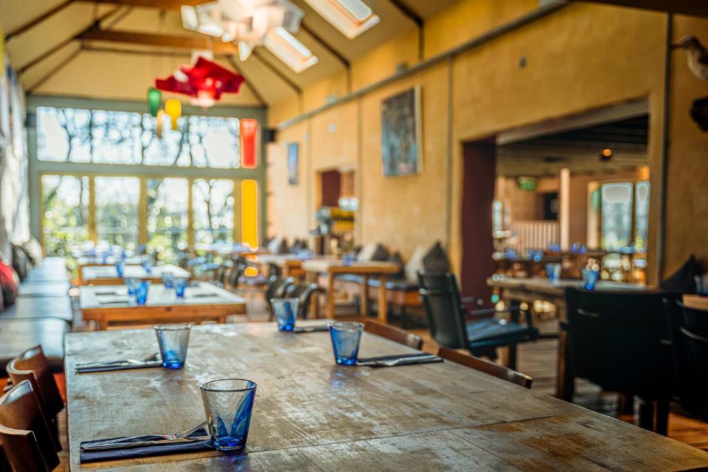 格拉斯顿伯里The Sheppey的餐厅设有木桌和玻璃杯