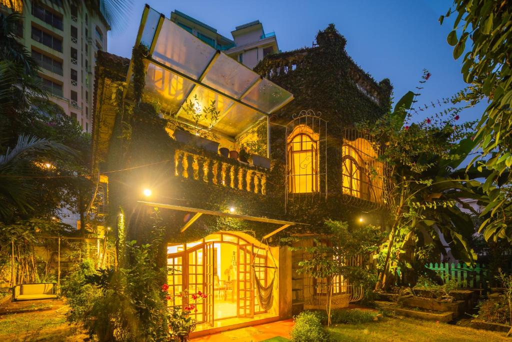 孟买SaffronStays Birdsong, Madh - pet-friendly villa at Madh Island的一座在晚上有灯的大建筑