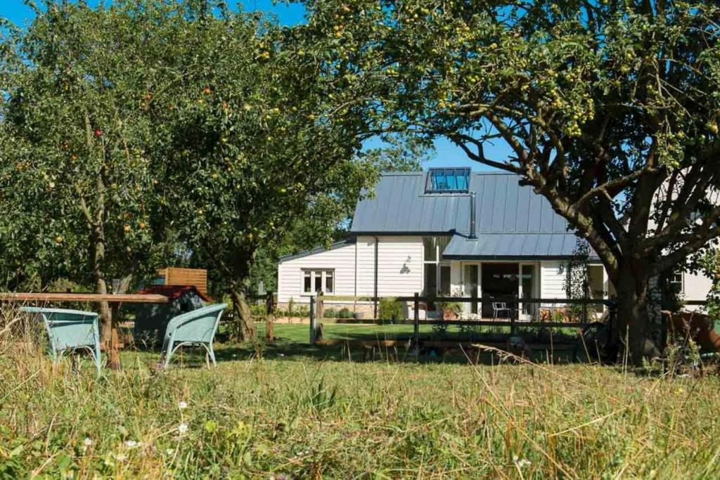 Old NewtonSkylarks, enjoy the decking overlooking your garden and wildflower meadow的白色的房子,两把椅子和一棵树