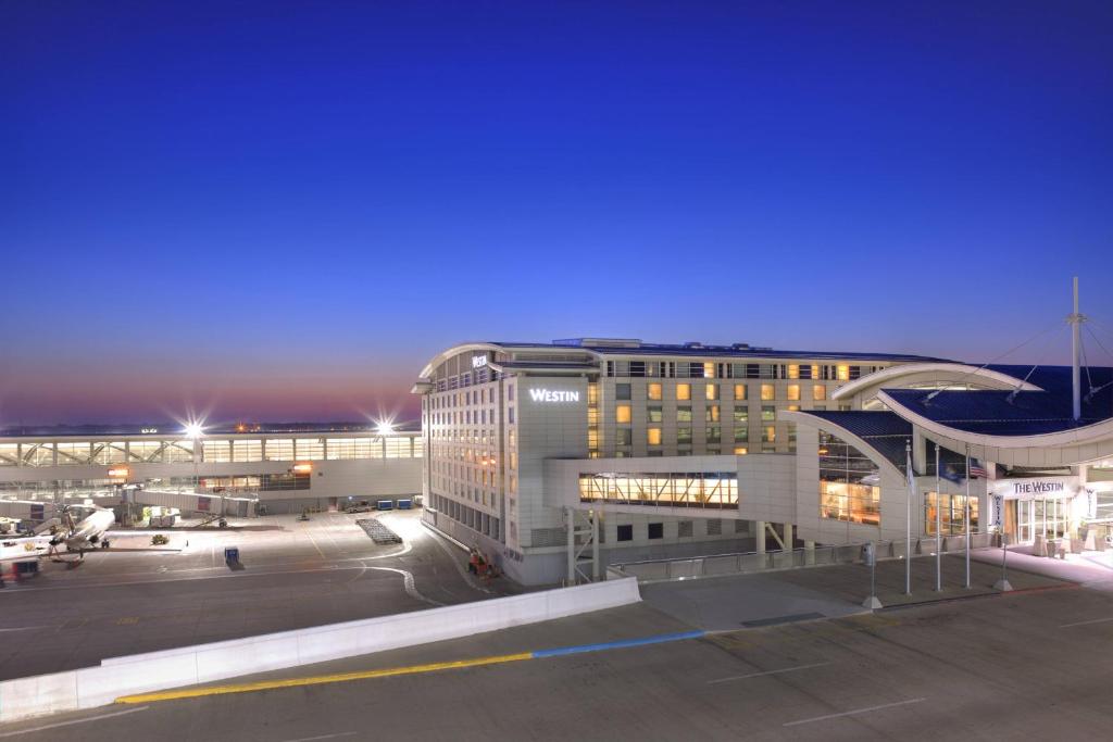 罗缪勒斯The Westin Detroit Metropolitan Airport的一座大型建筑,前面设有停车场