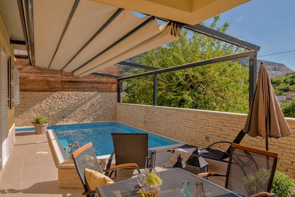兹诺夫尼卡Luxury Villa LeLu with heated saltwater pool, parking, high speed Internet, BBQ,的一个带游泳池和遮阳伞的庭院