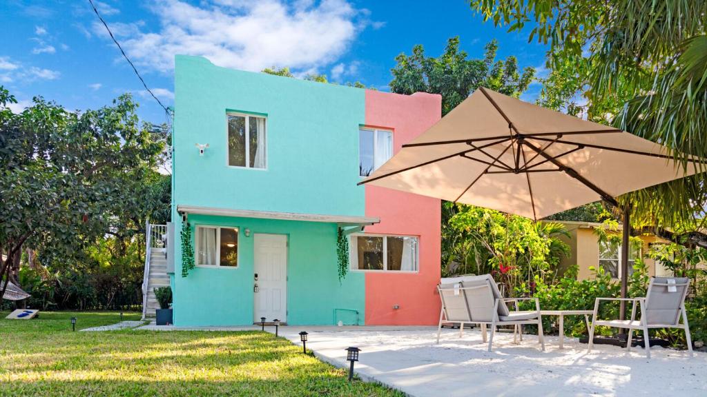 迈阿密Wynwood's Urban Oasis的色彩缤纷的房屋,配有椅子和雨伞