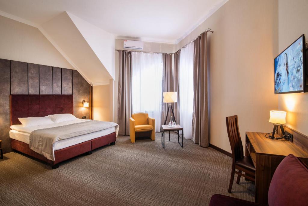 捷尔诺波尔Байків的大型酒店客房,配有一张床和一张书桌