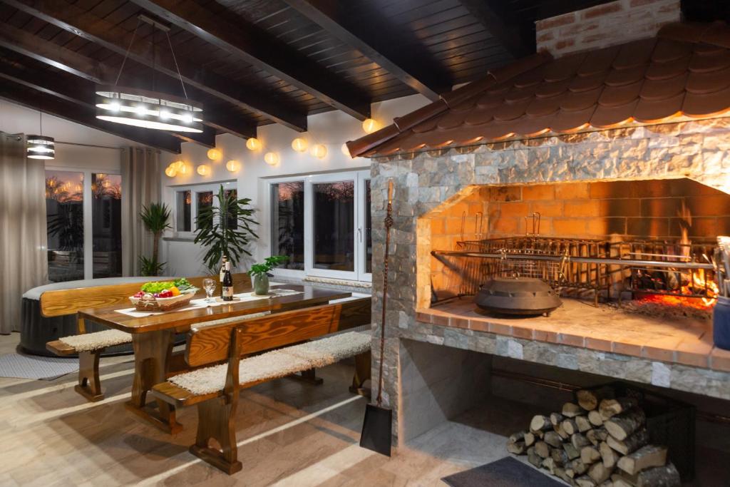 VrhovineKuća za odmor 'Teuta'的厨房配有带木桌的大型石制壁炉