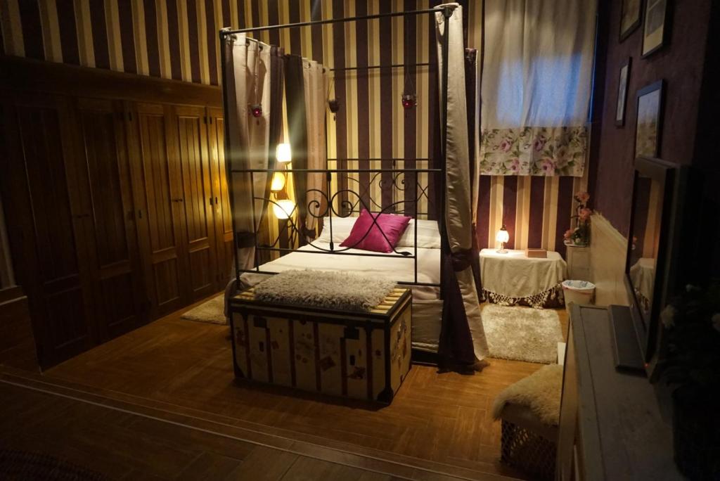曼萨纳雷斯-埃尔雷亚尔Lantica roccia的一间设有天蓬床的房间,里面设有长凳