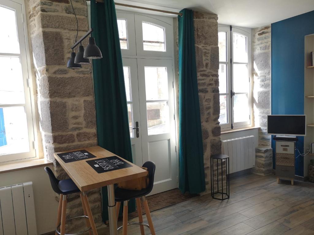 格朗维尔Haute ville : studio ravissant的客房设有桌椅和窗户。