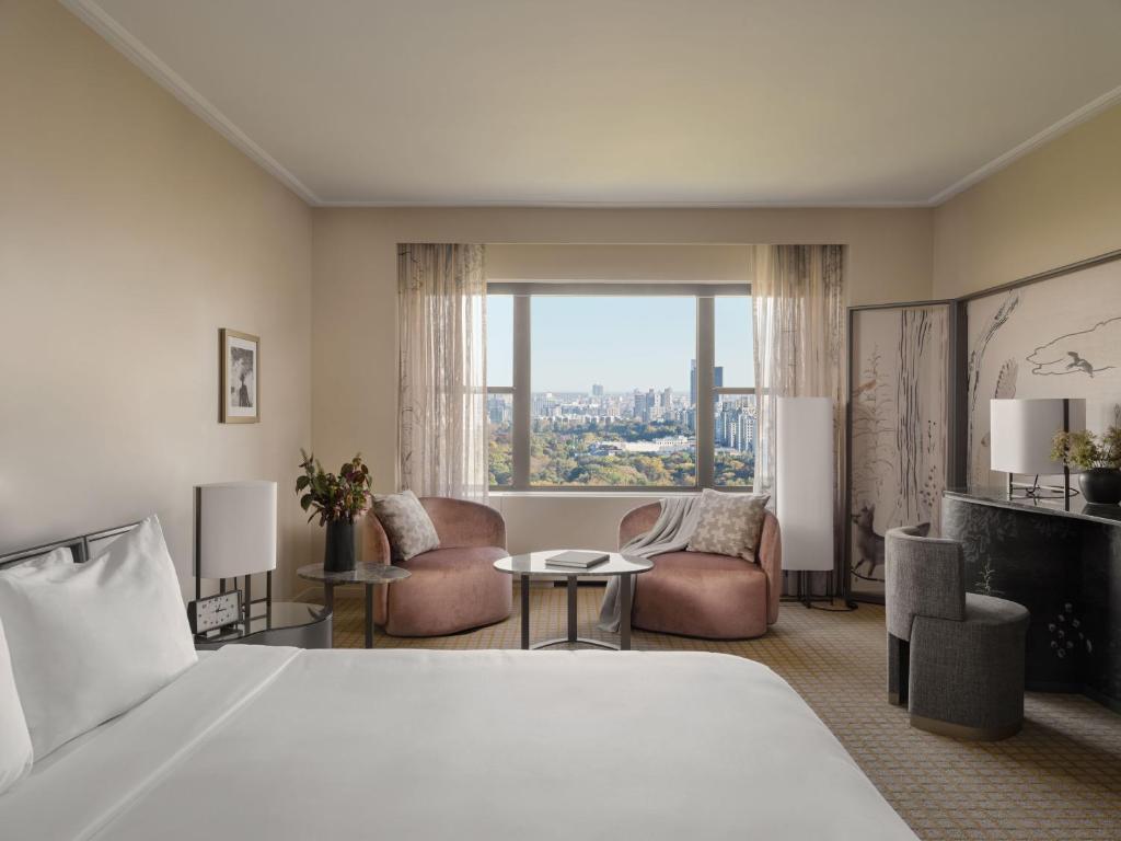 纽约Park Lane New York的酒店客房设有一张床和一个大窗户