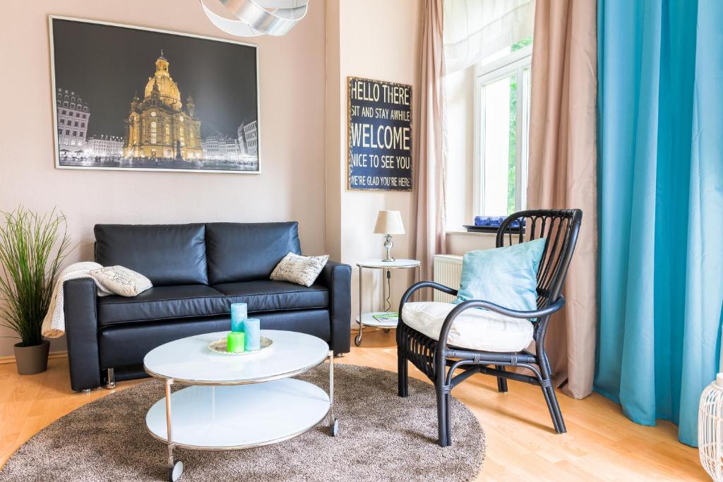 德累斯顿DD-洛博陶1公寓的客厅配有沙发和两把椅子