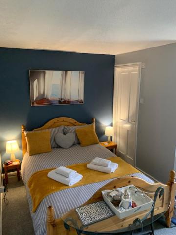 剑桥冬青树住宿加早餐旅馆的一间卧室配有一张床,上面有两条毛巾