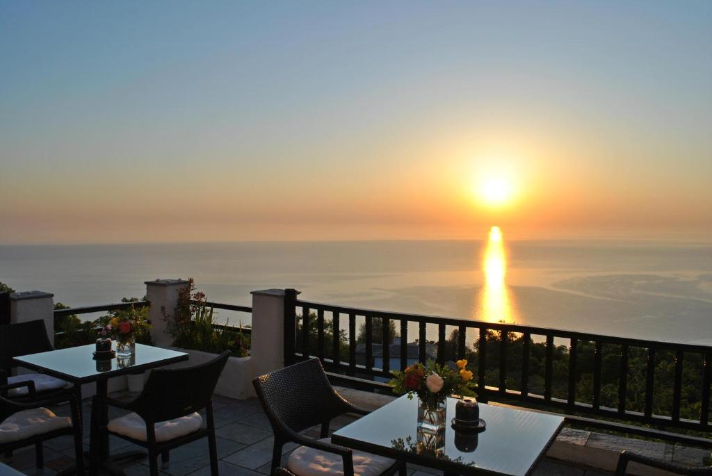 圣季米特里奥斯埃尔达古宅酒店的露台配有桌椅,享有日落美景。