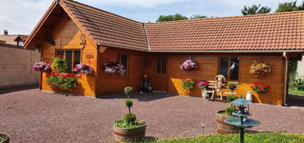 Saint-Quentin-Lamotte-Croix-au-BaillyLe chalet的前面有鲜花的小木屋