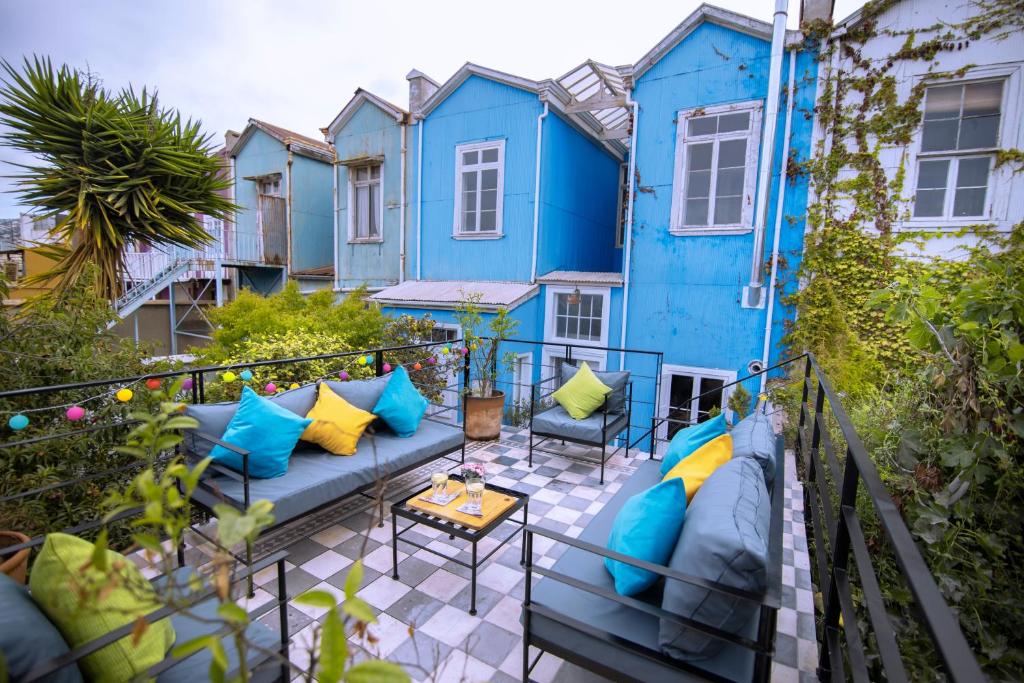 瓦尔帕莱索New Voga Guesthouse的一个带蓝色家具的庭院和蓝色的房子