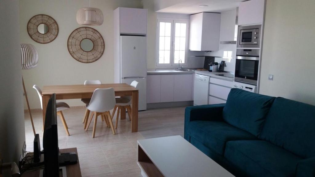阿尔么丽亚Apartments Sol de Almeria Golf y Playa II的客厅配有蓝色的沙发和桌子