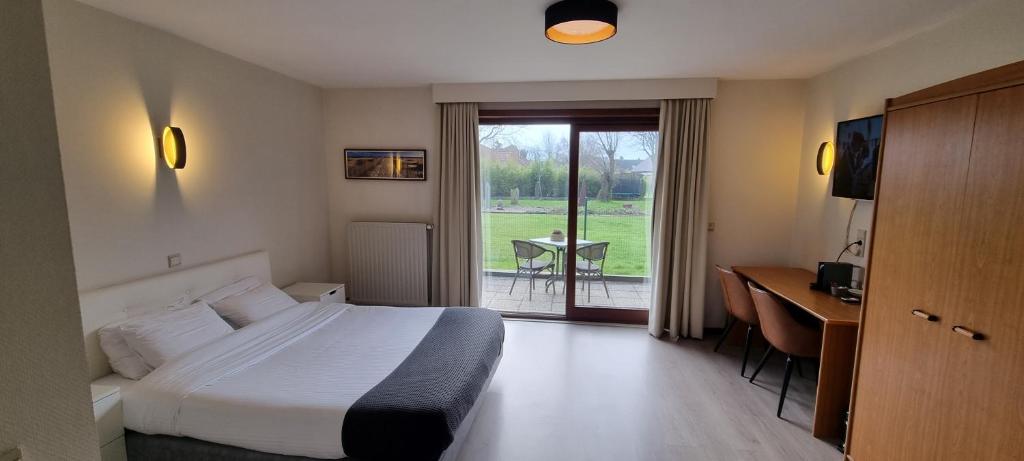 米德尔克尔克韦斯特恩迪亚酒店的配有一张床、一张书桌和一扇窗户的酒店客房