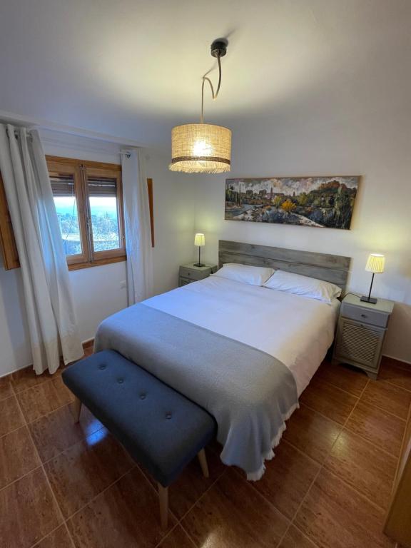 RadiqueroCasa Grasa的卧室配有一张白色大床和吊灯。