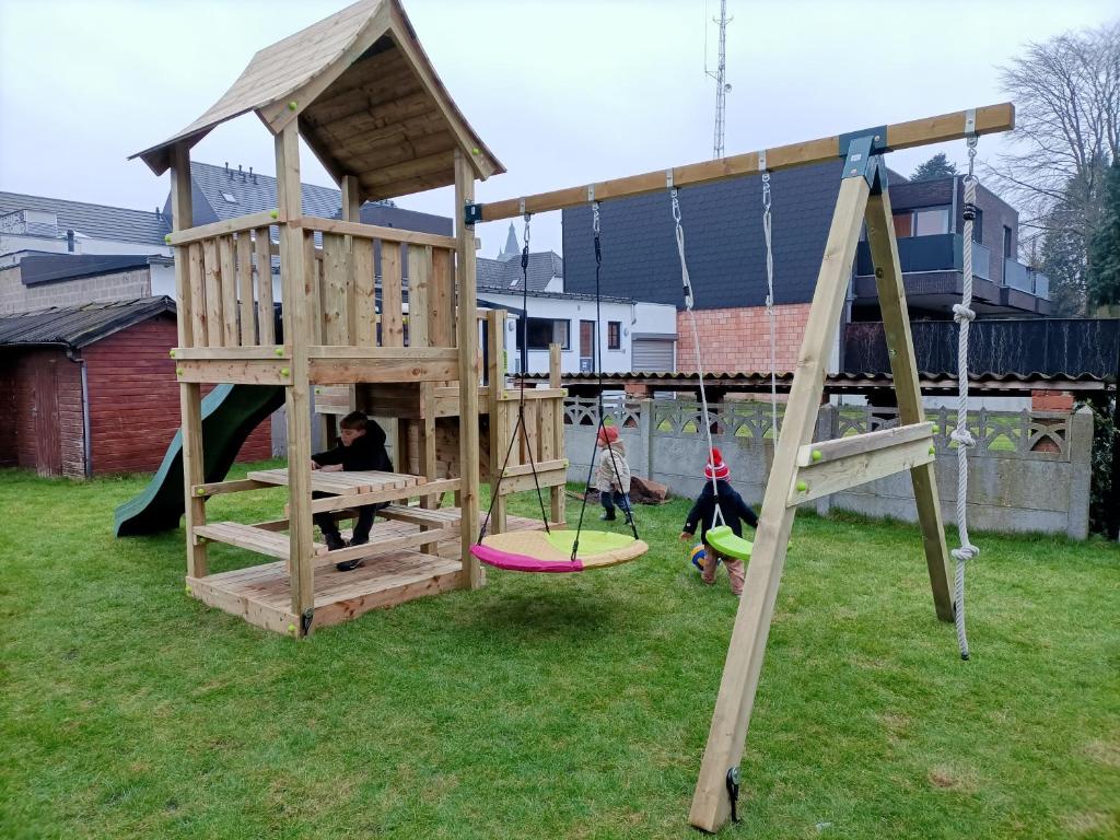 佩尔Moodraz vakantiehuis centrum Peer的两个孩子在带木游戏结构的游乐场玩耍