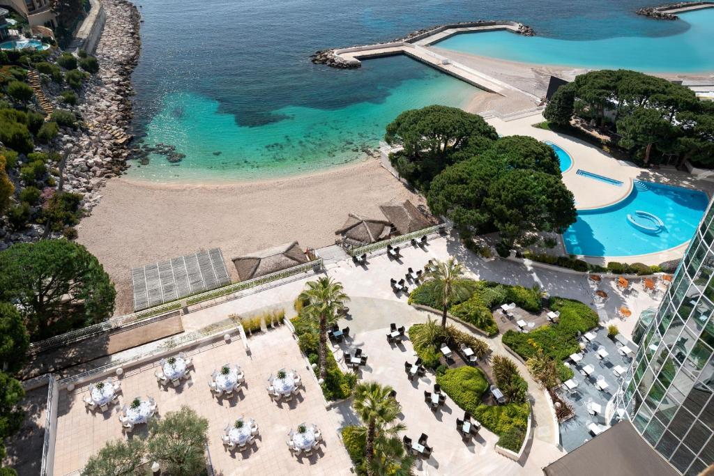 蒙特卡罗艾美度假酒店的享有海滩和游泳池的度假村的空中景致