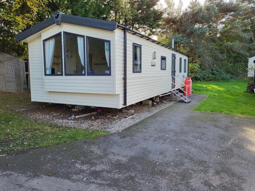 布莱克浦Caravan Kensington 46 at Marton Mere Blackpool的停在院子里的白色小房子