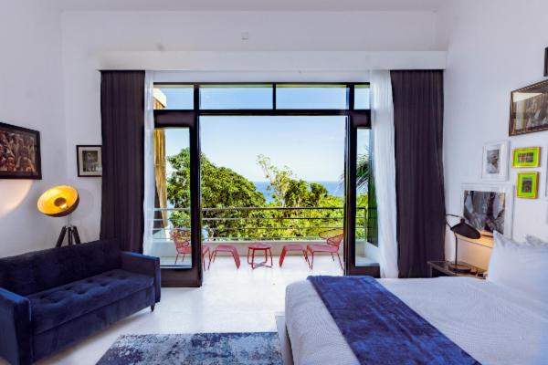 安东尼奥港吉加姆酒店的一间卧室设有一张床,享有阳台的景色