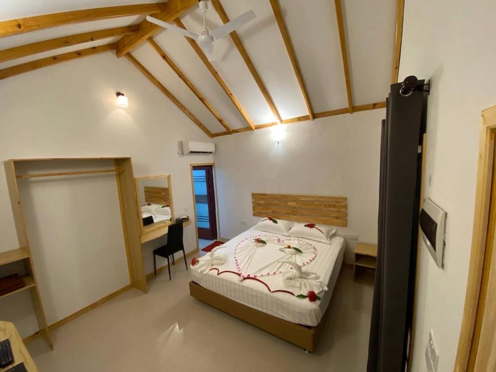 图杜Thoddoo Haisha inn, Maldives的一间卧室配有一张床和一张书桌