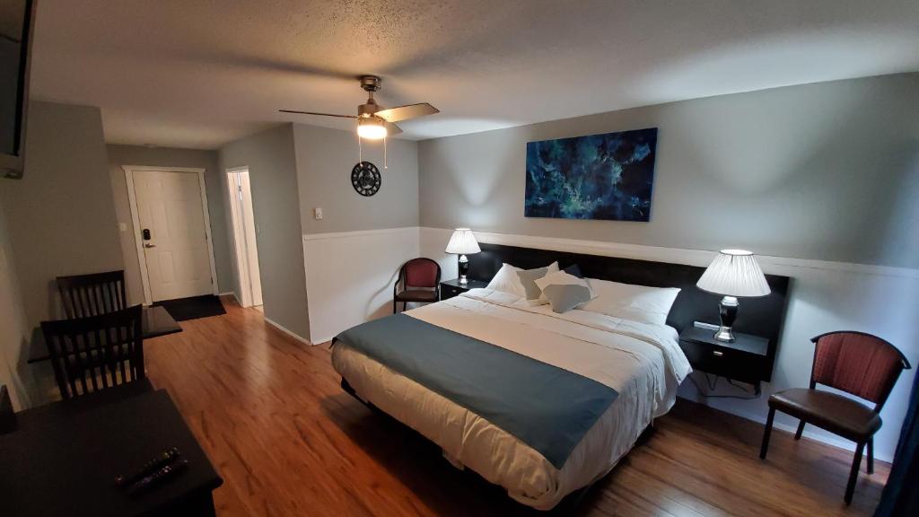 镭温泉Celadon Lodge的酒店客房带一张大床和两张椅子