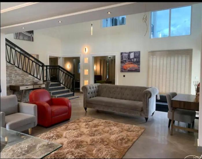 阿克拉AlanVal Suites的带沙发和红色椅子的客厅