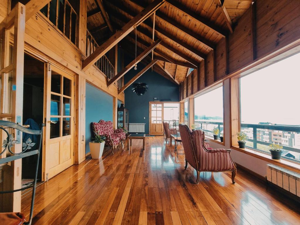 乌斯怀亚FLOR AUSTRAL的大型客厅铺有木地板,设有大窗户