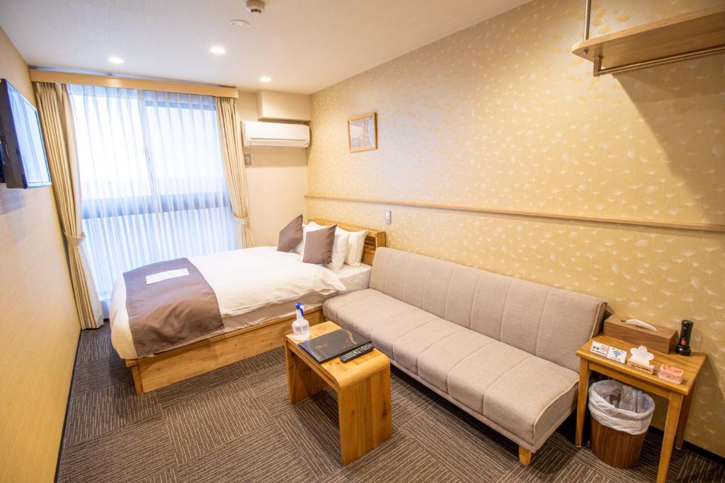 京都Stay SAKURA Kyoto Shijo Karasuma的酒店客房,配有床和沙发