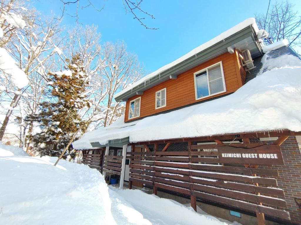 白马村Keimichi Guest House的小木屋,屋顶上积雪